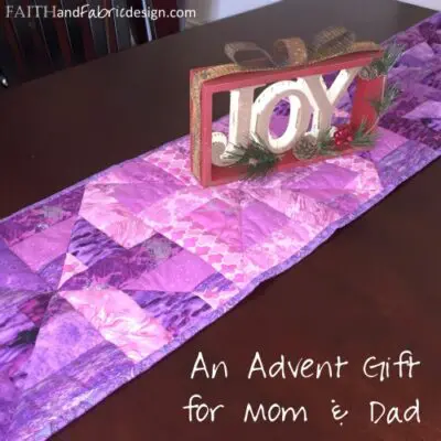 Purple quilted table runner with JOY sign
