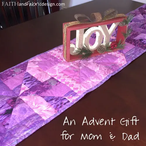 Purple quilted table runner with JOY sign